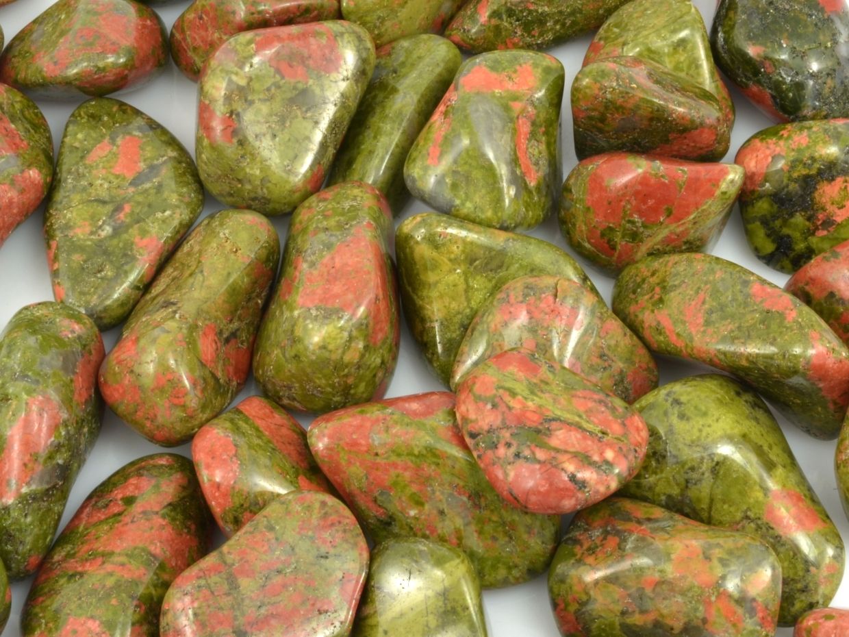 Tromlované zeleno-růžové kameny unakitu.