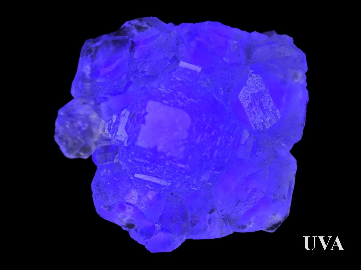 Xianghualing fluorit pod UV světlem září modře a fialově.