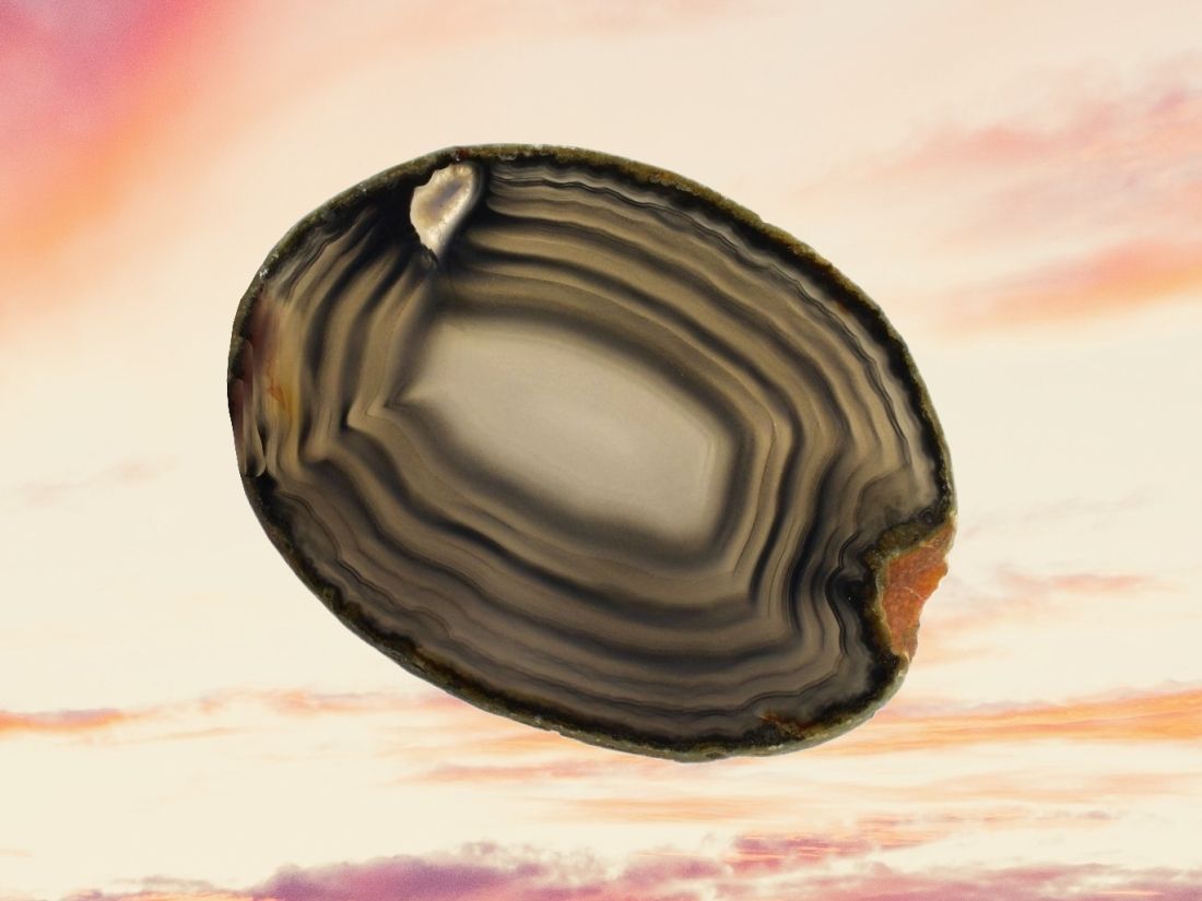 Páskovaný černý achátový plátek se světlými liniemi, minerál síly a harmonie.