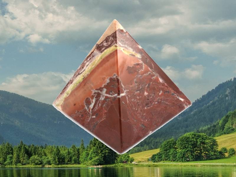 Pyramida z aragonitu v prostředí zalesněných hor.