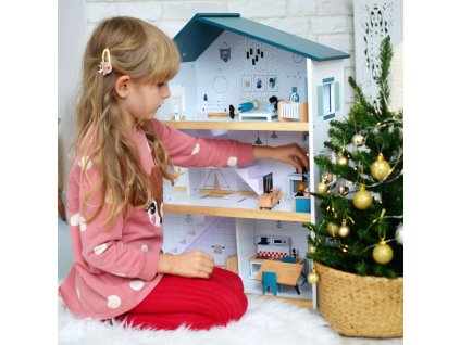 Dievčatko hrajúce sa s domčekom pre bábiky