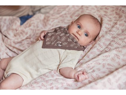 Bábätko ležiace na deke s hnedým bandana podbradníkom s prírodným vzorom