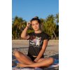 tee mockup of a bronzed woman sitting by palm trees at the beach 26802
