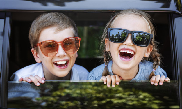 happy-kids-looking-out-car-window_53876-30797