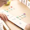 Learn and Grow toys metal rimmed counting chips and numeracy toppers being used by a young girl