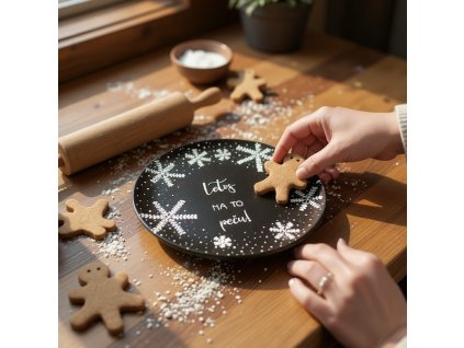 Close up lifestyle shot, Warm and inviting kitchen scene during the Christmas holidays; the black snowflake patterned plate is casually placed on a rustic wooden countertop dusted with flour, scattered amongs