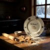 A charming, rustic kitchen scene bathed in warm, golden sunlight streaming through a window, casting long shadows across a wooden countertop A white, decorative plate featuring a whimsical, winged pig des (1)