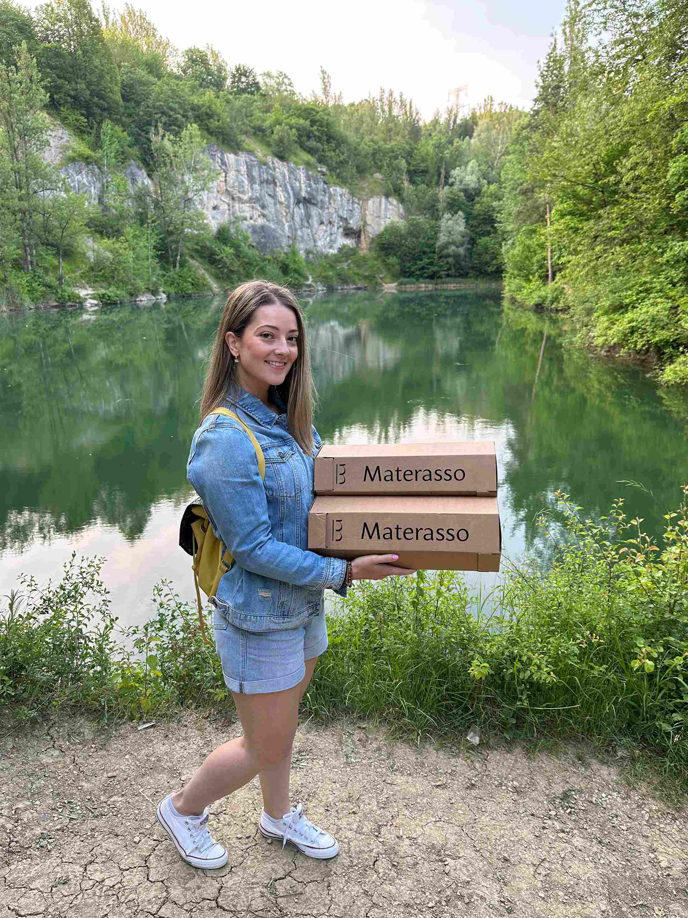 umievavá žena ukazuje anatomické vankúše Materasso pri krásnom jazere.