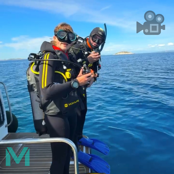 Instruktor potápění z Max Dives se studentkou před vstupem do vody z lodě v Chorvatsku