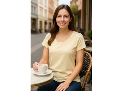 Žena v béžovom tričku a džínsach sedí pri káve na ulici – pohodlný a elegantný look