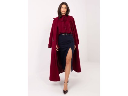 Modelka má na sebe elegantnú puzdrovú sukňu s vysokým pásom, opaskom a predným rozparkom, doplnenú štýlovou blúzkou a lodičkami.