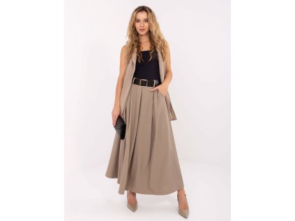 Modelka má na sebe elegantnú maxi sukňu so záhybmi a opaskom, doplnenú blúzkou a lodičkami pre sofistikovaný ženský vzhľad.