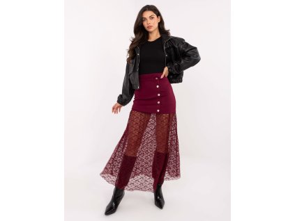 Modelka v čiernej mini sukni s gombíkmi a priehľadným čipkovým spodným dielom, doplnená koženou bundou a vysokými čižmami.