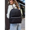 Dámsky čierny kožený batoh na ramene modelky, elegantný mestský ruksak z pravej kože s predným zipsovým vreckom.