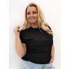 Modelka v plus size tričku s kvetinovou aplikáciou.