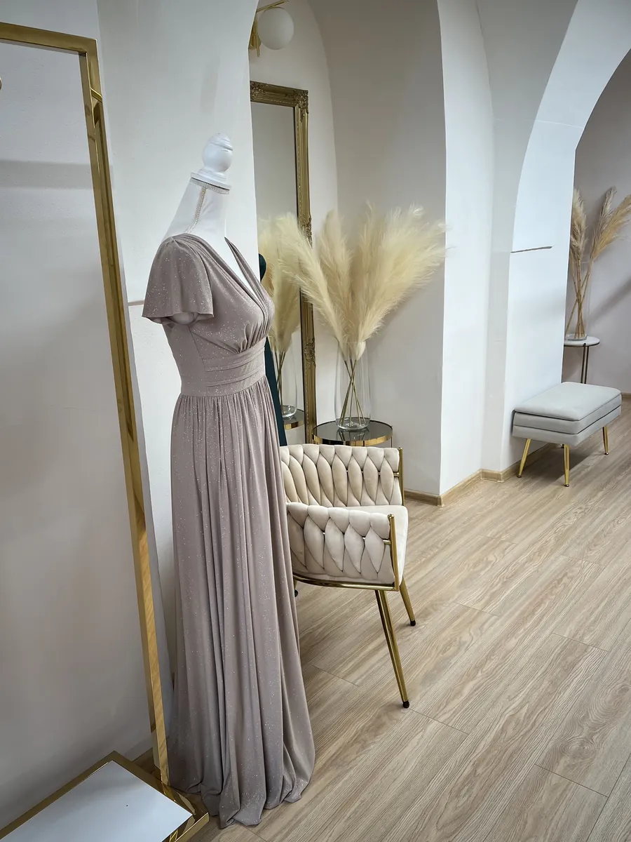 Interiér predajne Mia Dresses v Košiciach — dlhé spoločenské šaty a skúšobné zrkadlo