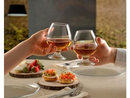 Két ember koccint Konyakos Bistro pohárral.