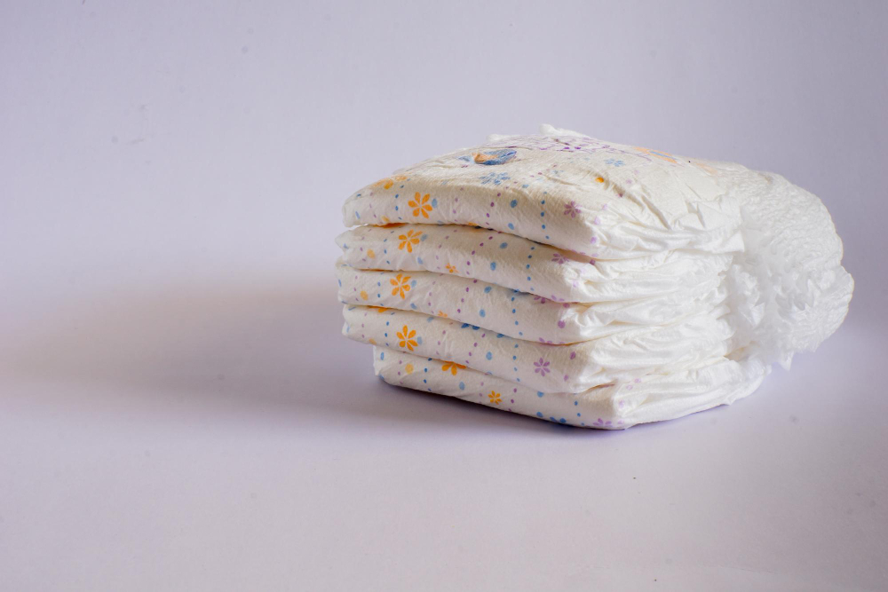 Čtyři složené dětské pleny položené na světlém pozadí.
