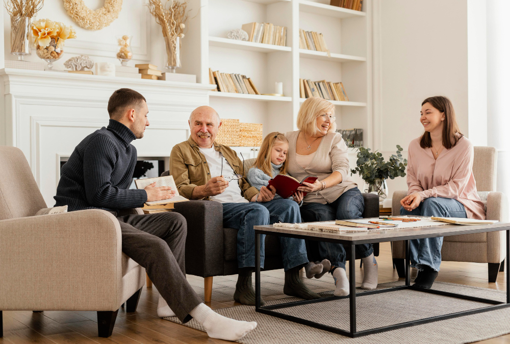 Rodina několika generací sedí v obývacím pokoji, povídá si a hraje povídací hry a slovní hry na párty při společném setkání.