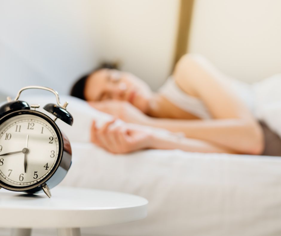 Woman with alarm clock in the morning, circadian rhythm and morning light
