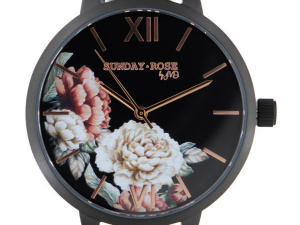  Elegantní vzhled hodinek podtrhuje náramek z černé kůže, kulaté pouzdro z černěné oceli s povrchovou úpravou IPBlack a černý ciferník s květinovým motivem (detail)