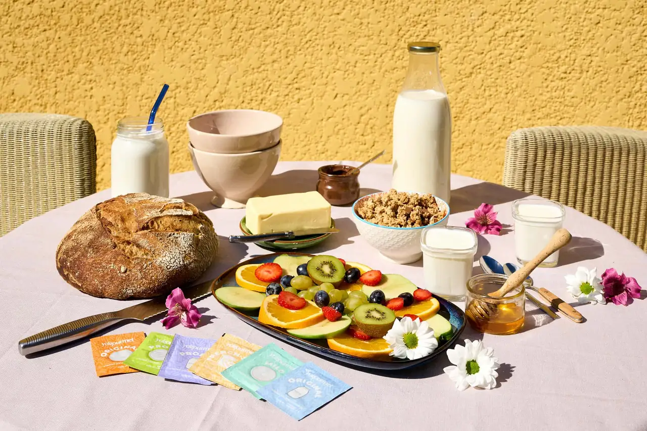 Sáčky kultúr Yogourmet na raňajkovom stole s mliekom, bielymi fermentovanými výrobkami a ovocím