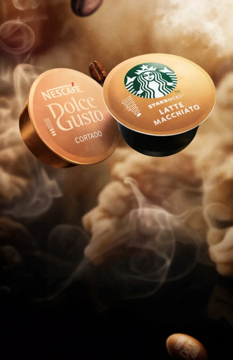 Dos cápsulas Dolce Gusto detrás de nubes de vapor de la cafetera