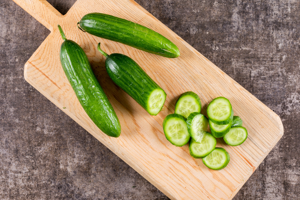 top-view-cucumber-sliced-wooden-cutting-board-brown-stone-horizontal-1