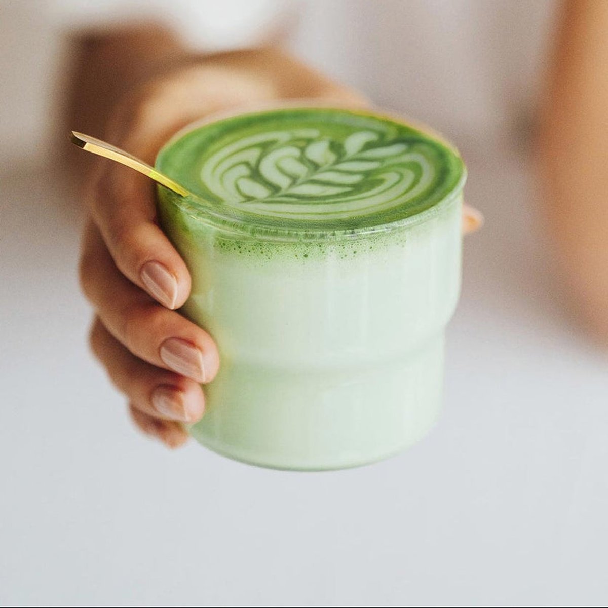 Ruka drží sklenici s matcha latte