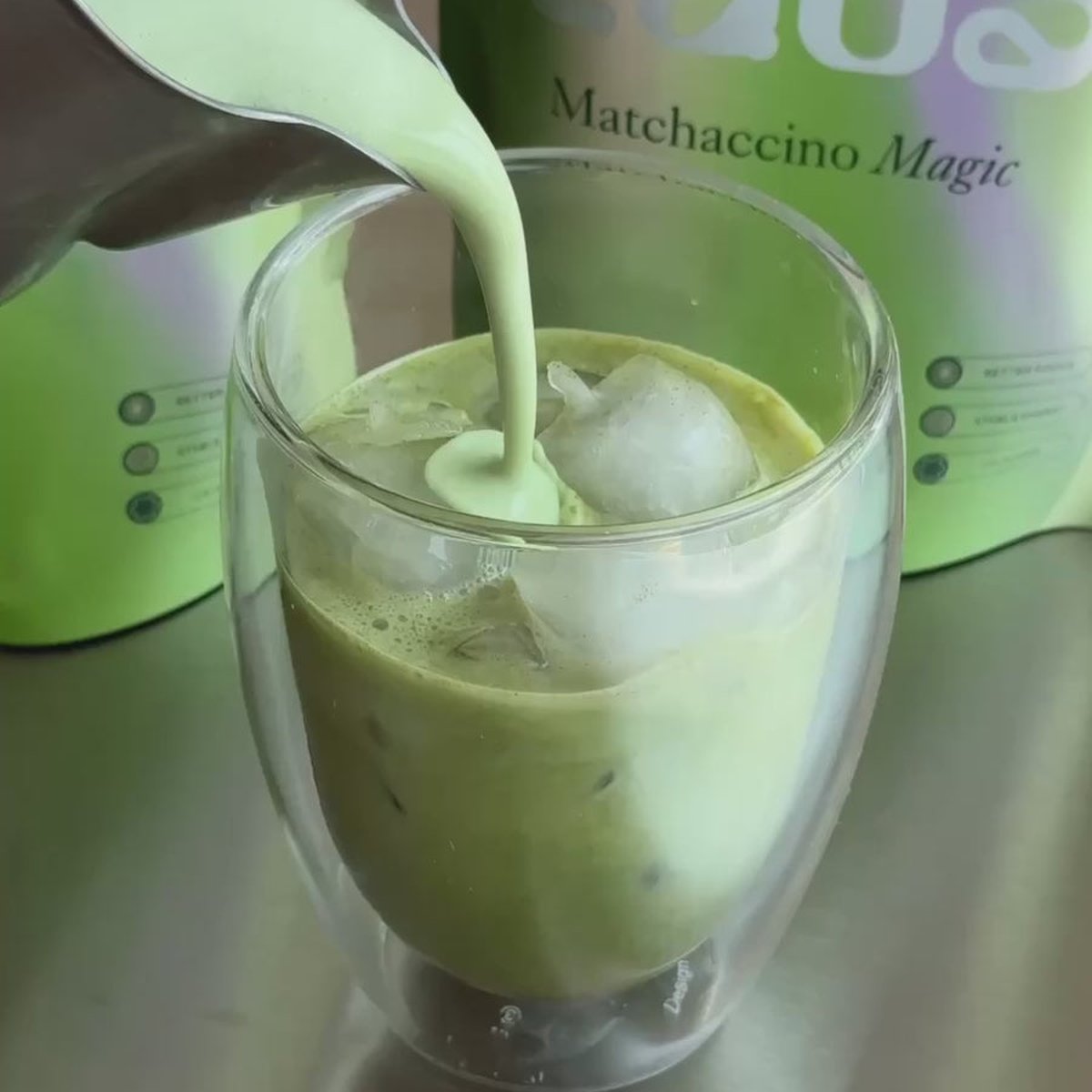 Nalévání matcha latte do sklenice vedle sáčku Matchaccino Magic