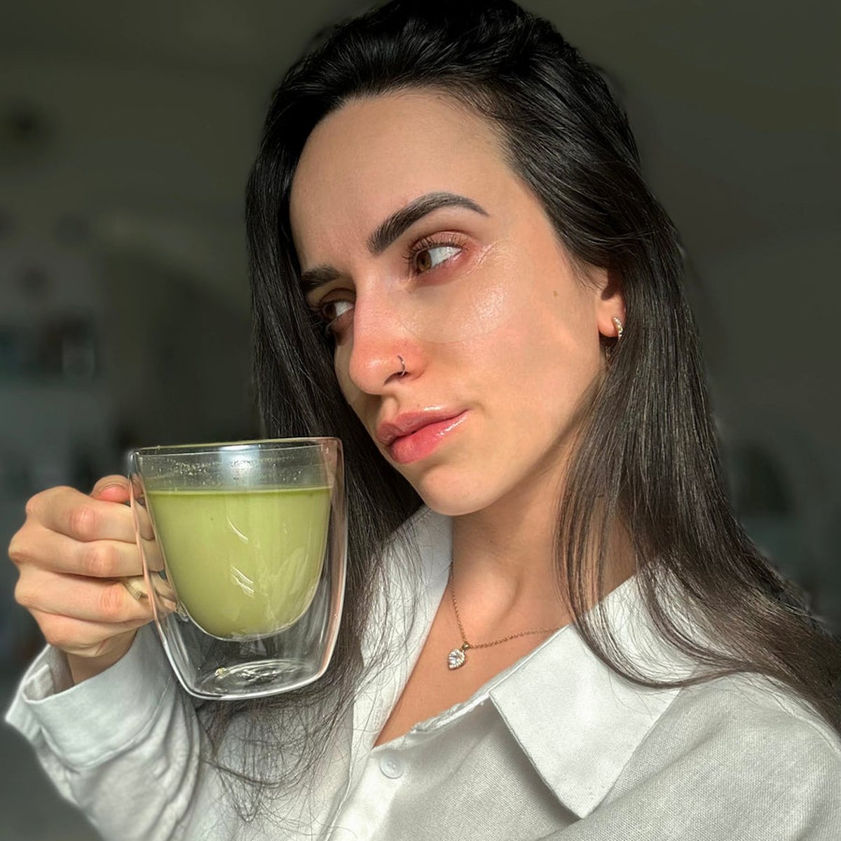 Žena drží sklenici Matchaccino Magic
