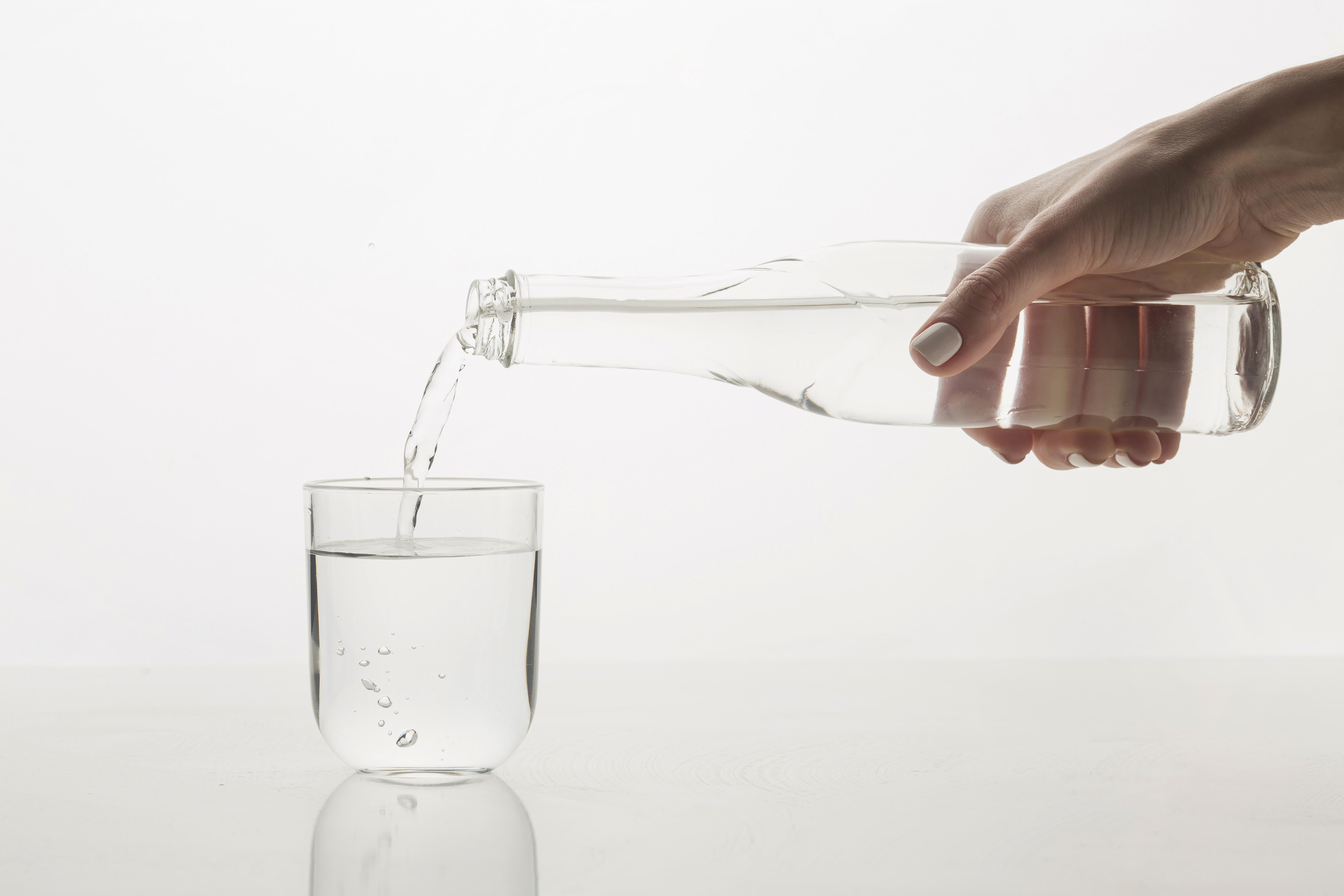 person-pouring-water-glass-front-view