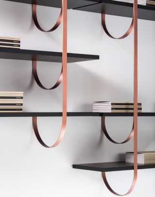 TALEA ◾️DeCastelli. Ze stropu sestupují tenké kolmé nosníky, které se jemnými oblouky upínají ke zdi. Podobně jako...