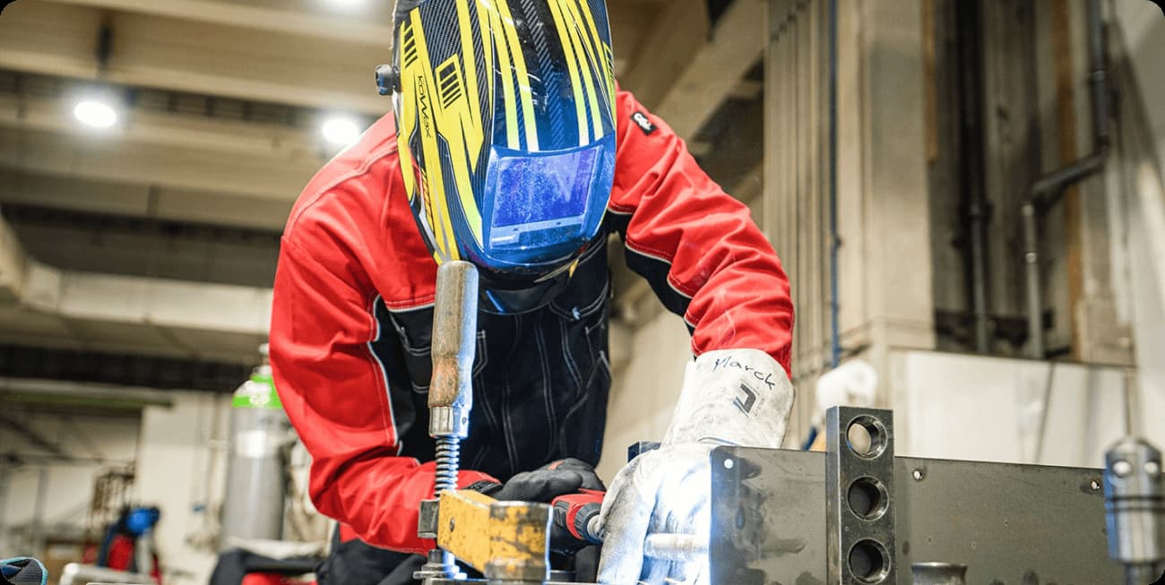 Řemeslník při svařování kovového výrobku v dílně