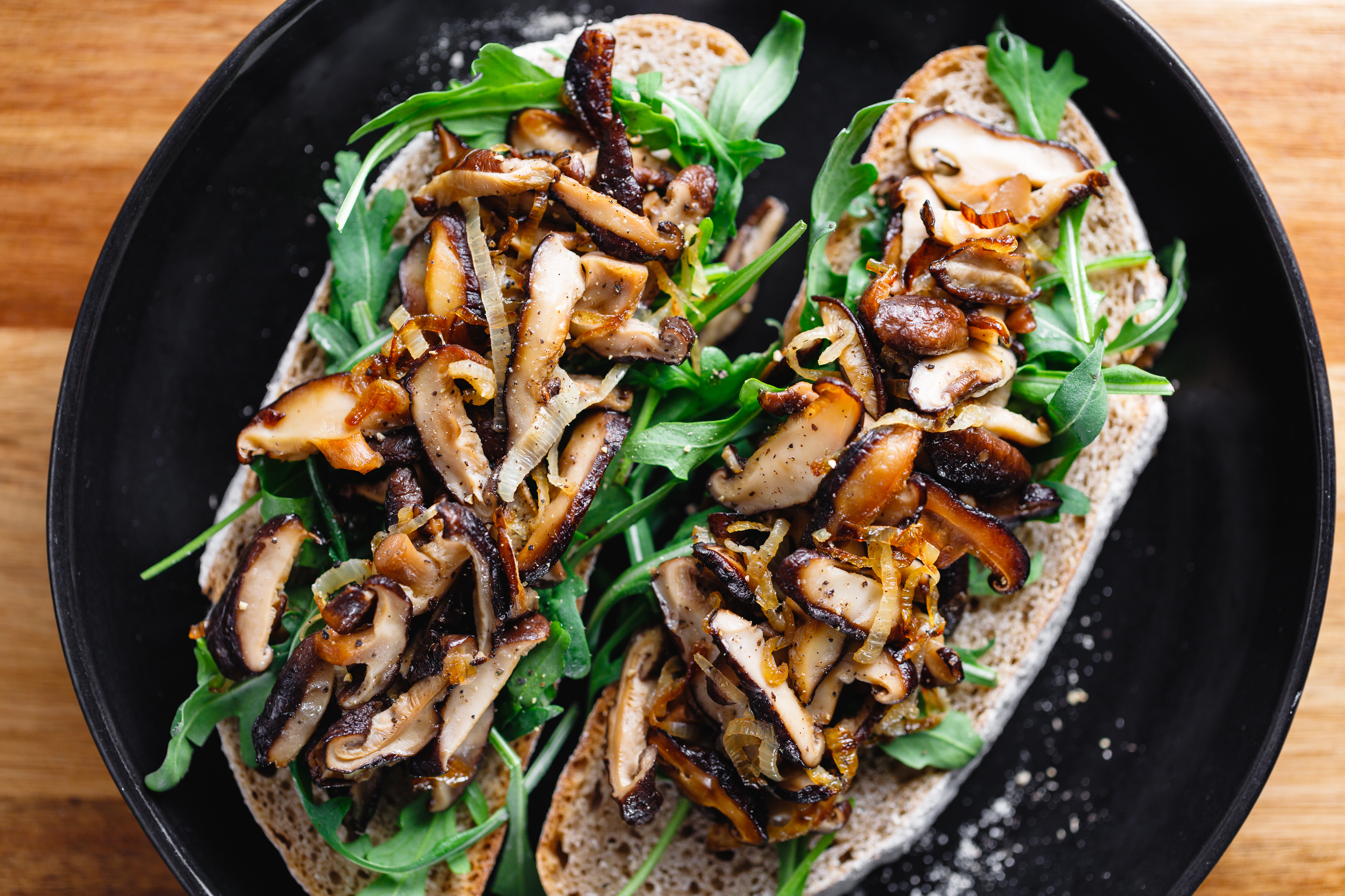 top-view-two-vegan-sandwiches-with-fresh-arugula-fried-shiitake-mushroom-shallot-onion