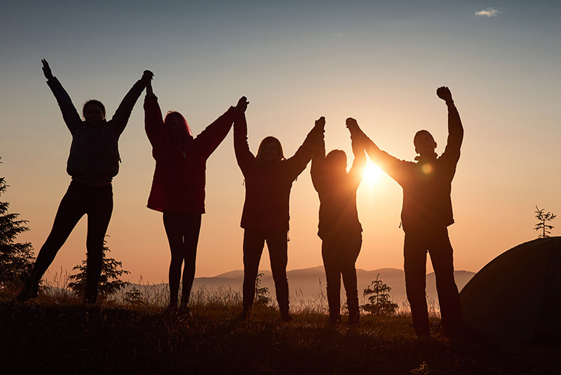 silhouette-group-people-have-fun-top-mountain-near-tent-during-sunset_w