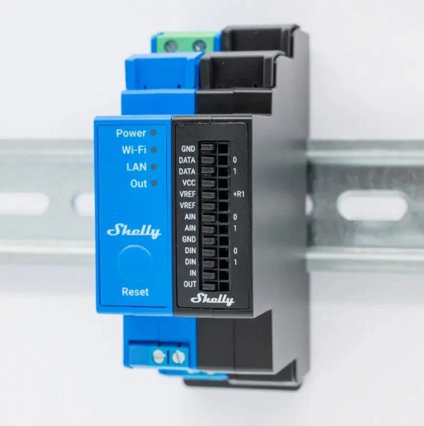 Shelly Pro Sensor Add-on připojený k zařízení Shelly Pro na DIN liště v elektrickém rozvaděči.