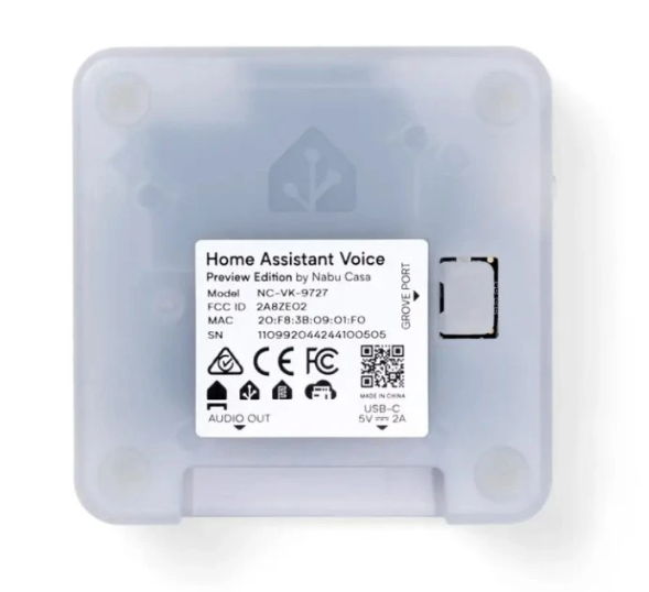 Spodní strana Home Assistant Voice Preview Edition s průsvitným krytem, výrobním štítkem, QR kódem, konektorem Grove a označením portů Audio Out a USB-C