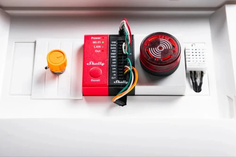 Ukázka instalace Shelly Pro Sensor Add-on v rozvaděči s připojeným alarmem a teplotním senzorem.