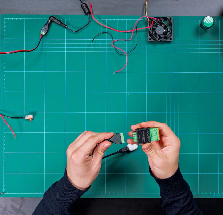 Instalace Shelly SSR Add-on během zapojování na pracovním stole s elektronickými komponenty