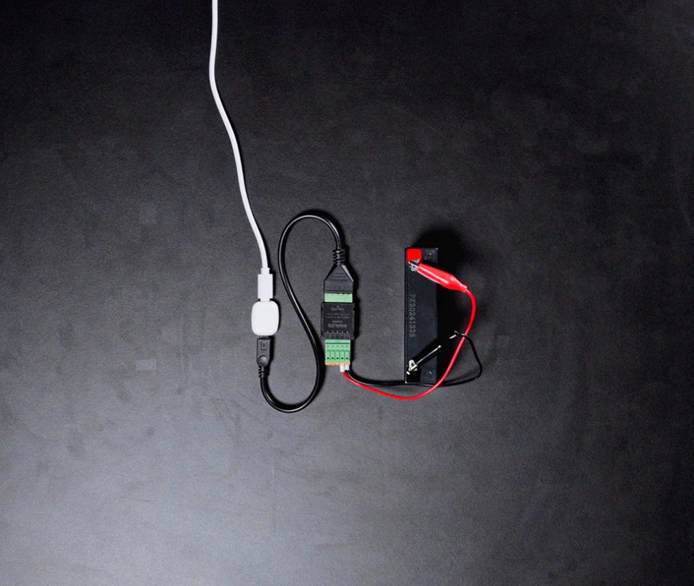 Shelly Analog 0–30 V Add-on připojený k USB napájení a analogovému senzoru při testování zapojení