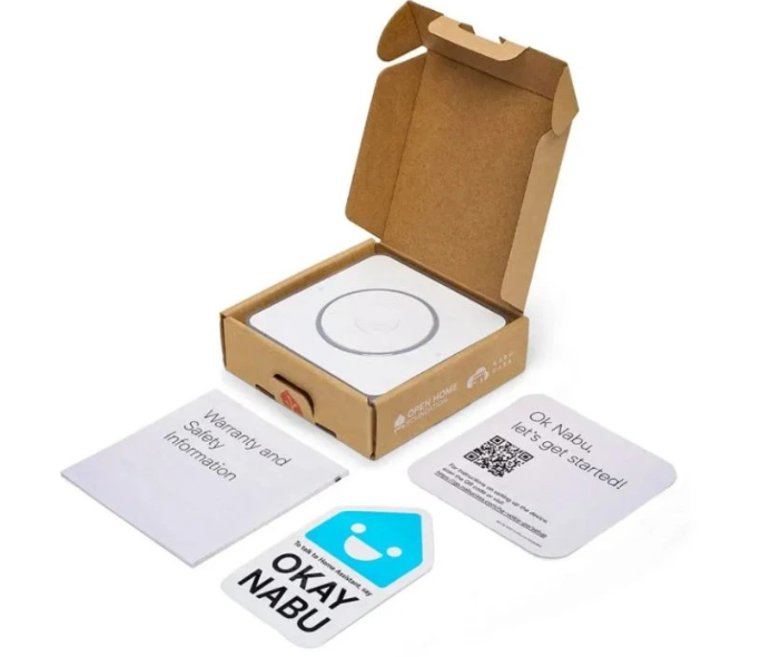 Otevřené balení Home Assistant Voice Preview Edition s hlasovým zařízením uloženým v kartonové krabici, informačními kartami, bezpečnostní dokumentací a samolepkou Okay Nabu