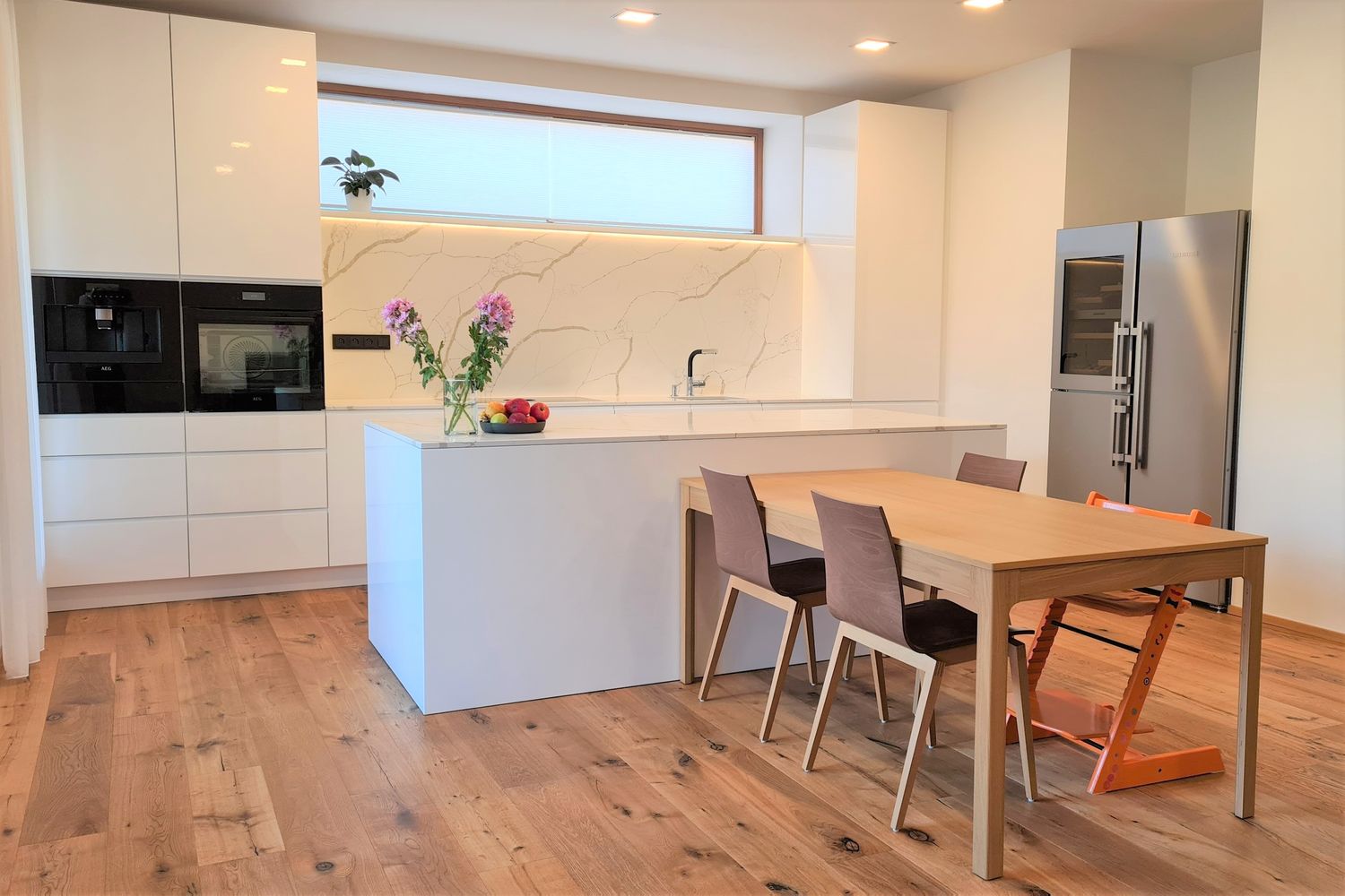 Bílá kuchyň s kamennou deskou na dubové podlaze