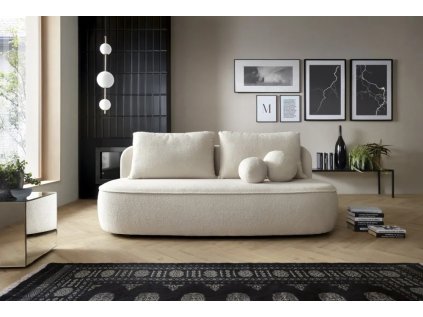 Rozkládací pohovka ANTOL SOFA ve světlém interiéru u stěny s dekoracemi, krémové čalounění, pohled zepředu.
