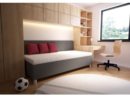 Čalouněná postel FIONA Blanář v interiéru pokoje, boční pohled na lůžko u okna s pracovním stolem a dekorem.