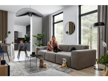 Pohovka CLOUD SOFA 3 v šedohnědém čalounění v moderním interiéru, dlouhý trojsed u velkých oken, pohled z úhlu.