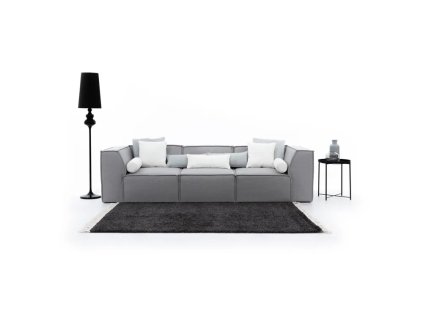 Sedací souprava LEXUS sofa 3 ve světle šedém provedení v interiéru, pohled zepředu s kobercem, lampou a dekoracemi.