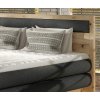 Boxspring postel LISA v ložnici, čelní pohled na ložnou plochu a čelo, tmavě šedé čalounění