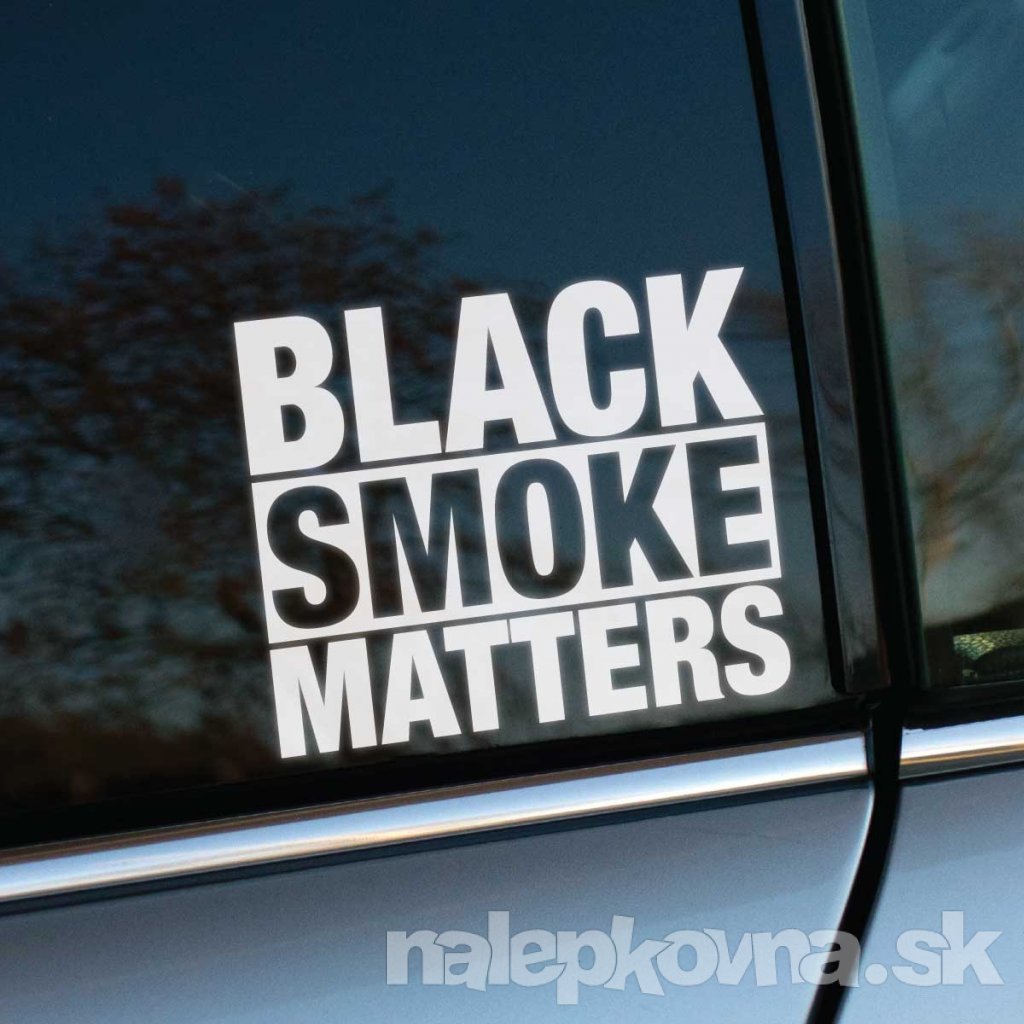 Fotografia zobrazuje bočné okno auta so samolepkou, na ktorej je veľkým bielym písmom napísané "BLACK SMOKE MATTERS". Tento nápis zdôrazňuje význam a podporu vozidlám, ktoré produkujú čierny dym, pravdepodobne odkazujúc na dieselové motory.