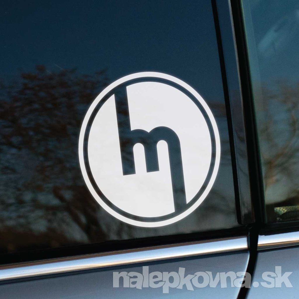 Plotrovaná nálepka s historickým logom značky Mazda, jednoduchý kruhový motív s písmenom M v minimalistickom spracovaní.